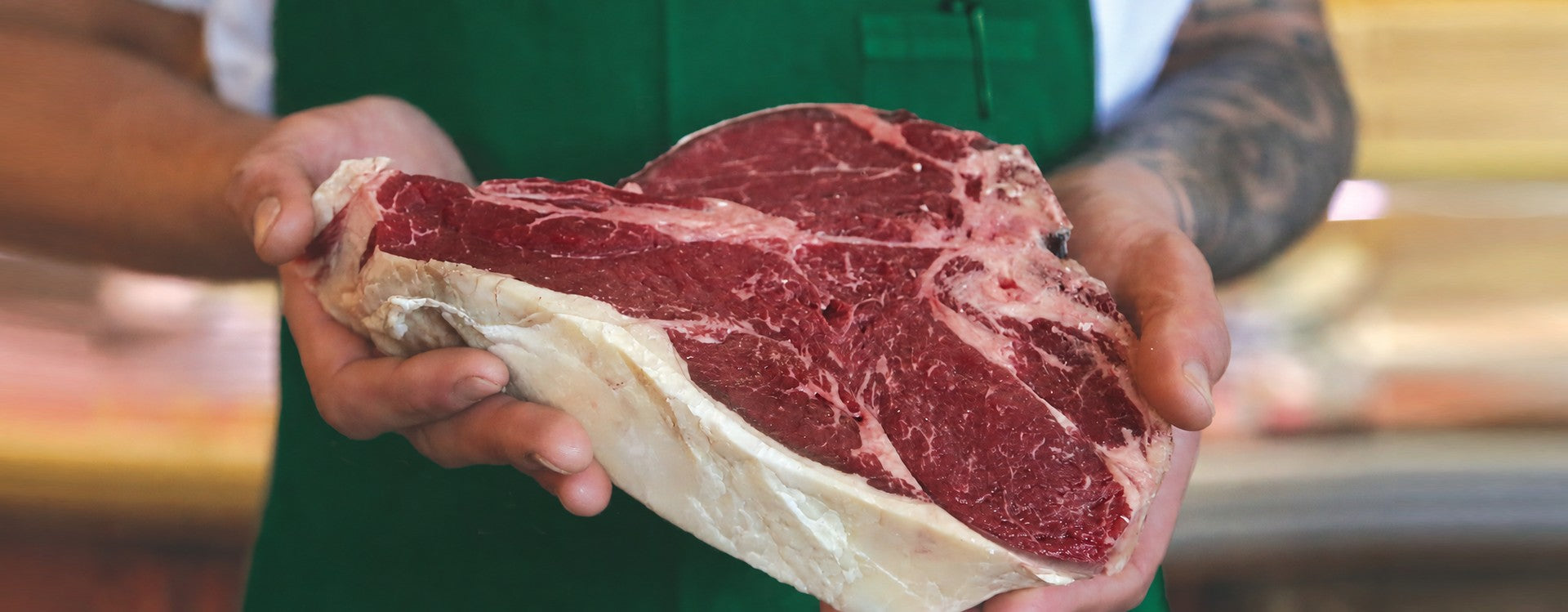 A butcher presenting a hand-cut beef steak